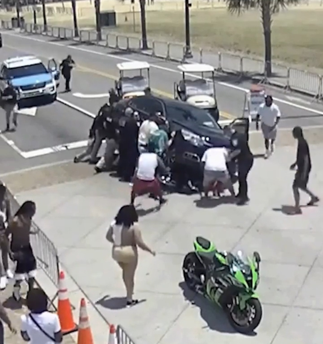 Passersby lift car to save trapped motorcyclist following accident