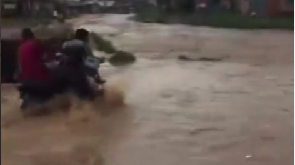 Bike rider swept away by flood after he refused to let go of his bike (video)