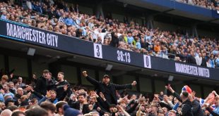 Manchester City fans celebrate as the scoreboard shows their team are 3-0 up against Manchester United in the derby at the Etihad Stadium.