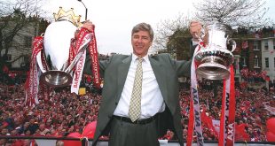 Arsene Wenger the Arsenal manager with the Premier League trophy and the FA Cup trophy during the Arsenal Trophy Parade on May 12, 2002 in London, England.