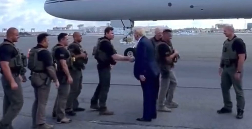 Trump is greeted by law enforcement as he arrives in Massachusetts.