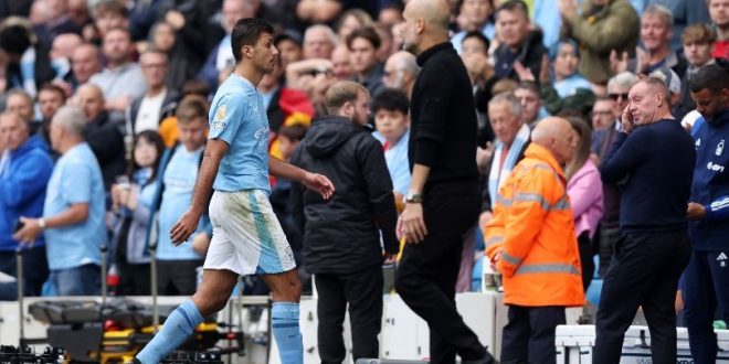 Rodri walks past Pep Guardiola following his red card in Manchester City