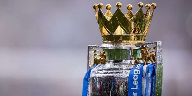 A close-up shot of the Premier League trophy in the rain