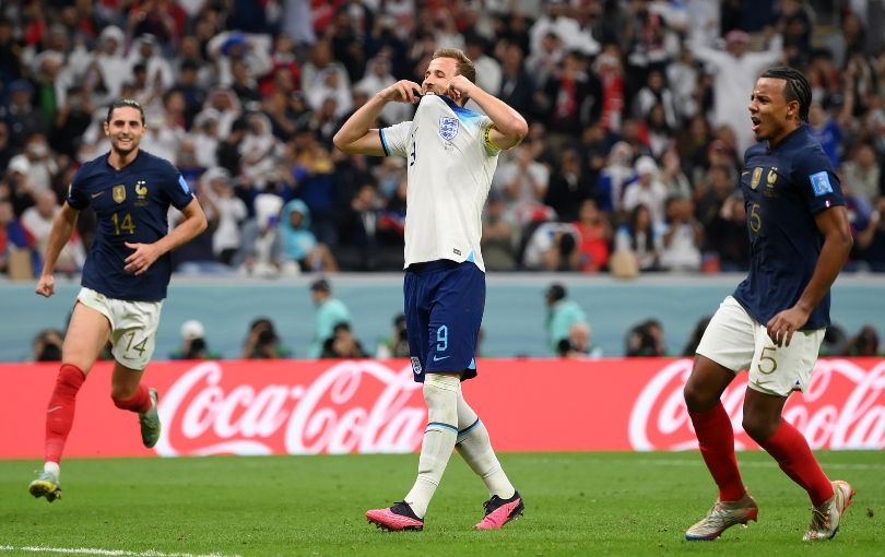 A frustrated Harry Kane with French players celebrating either side of him