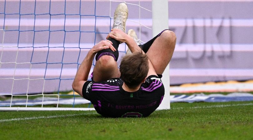 Harry Kane holds his knee after colliding with the post in Bayern Munich