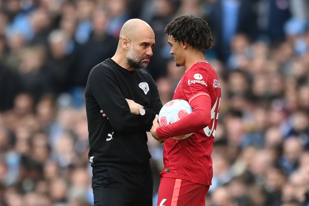 Manchester City manager Pep Guardiola shares a joke with Trent Alexander-Arnold of Liverpool during the Premier League match between Manchester City and Liverpool at Etihad Stadium on April 10, 2022 in Manchester, England. (Photo by Michael Regan/Getty Images)