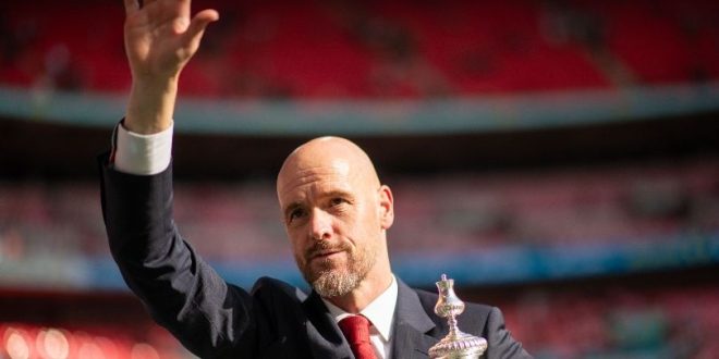 Erik ten Hag waves to Manchester United fans while holding the FA Cup after victory in the final over Manchester City in May 2024.