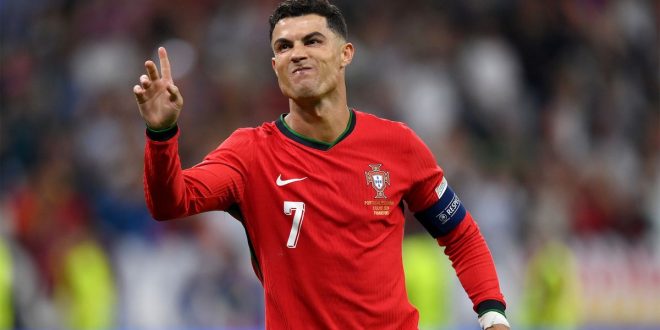 Cristiano Ronaldo raises his hand to celebrate scoring the first penalty in Portugal
