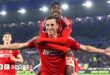 Chris Wood celebrates with his arms outstretched and Anthony Elanga jumping on his shoulders.