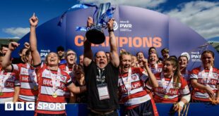 Sean Lynn (centre) holds the Premiership Women's Rugby trophy in the air surrounded by players after the club won the final last season