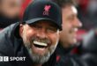 Jurgen Klopp smiling in a Liverpool hat