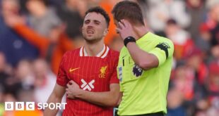 Liverpool forward Diogo Jota holds his side in pain