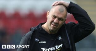 Leicester Tiger's Michael Cheika has his hand on his head while walking off the pitch