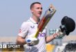 Harry Brook lifts his bat and helmet after his triple century