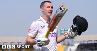 Harry Brook lifts his bat and helmet after his triple century