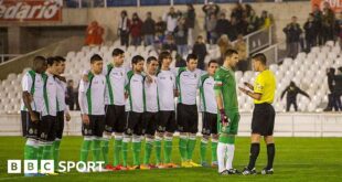 Racing Santander players speak to the referee