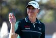 English golfer Charley Hull holds up the ball after making a putt during the third round of The Annika