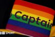 A rainbow-coloured Premier League captain's armband sits in front of a black background