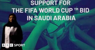 A woman stands in front of a 'support for the Fifa World Cup bid in Saudi Arabia'