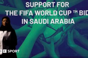 A woman stands in front of a 'support for the Fifa World Cup bid in Saudi Arabia'