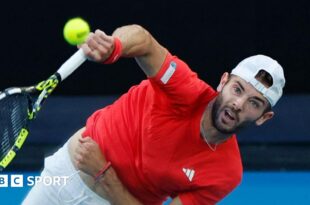 Jacob Fearnley hits a serve against Nick Kyrgios at the Australian Open