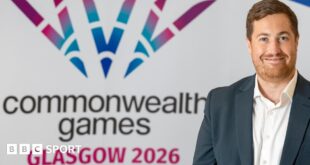 Phil Batty in front of a Commonwealth Games logo