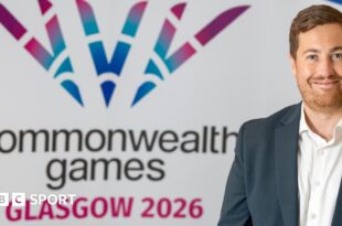 Phil Batty in front of a Commonwealth Games logo