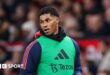 Marcus Rashford in a warm-up bib on the sidelines