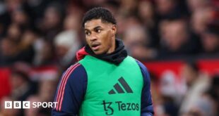 Marcus Rashford in a warm-up bib on the sidelines