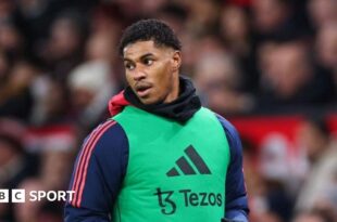 Marcus Rashford in a warm-up bib on the sidelines